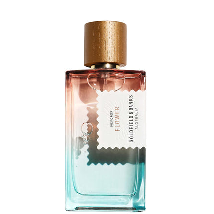 Perfume bottle with gold cap and gradient design on a white background