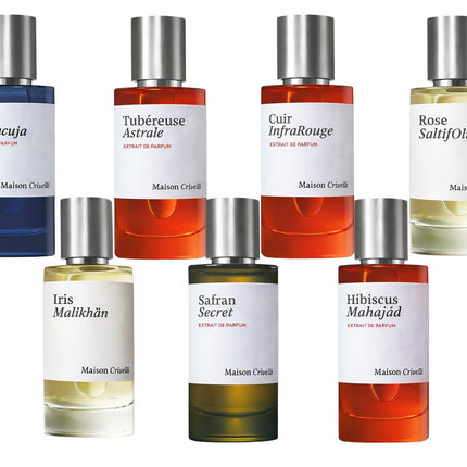 Collection of Maison Cruse perfume bottles with various colored labels on a white background
