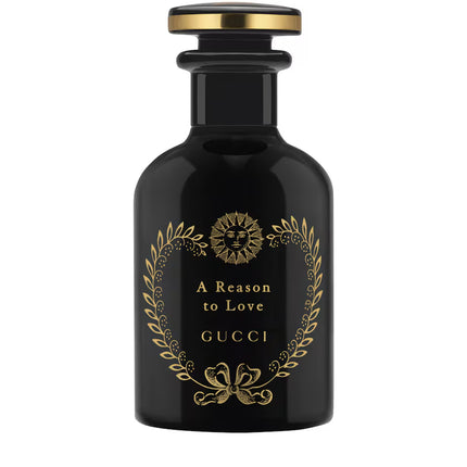 Black Gucci perfume bottle with gold accents on a white background